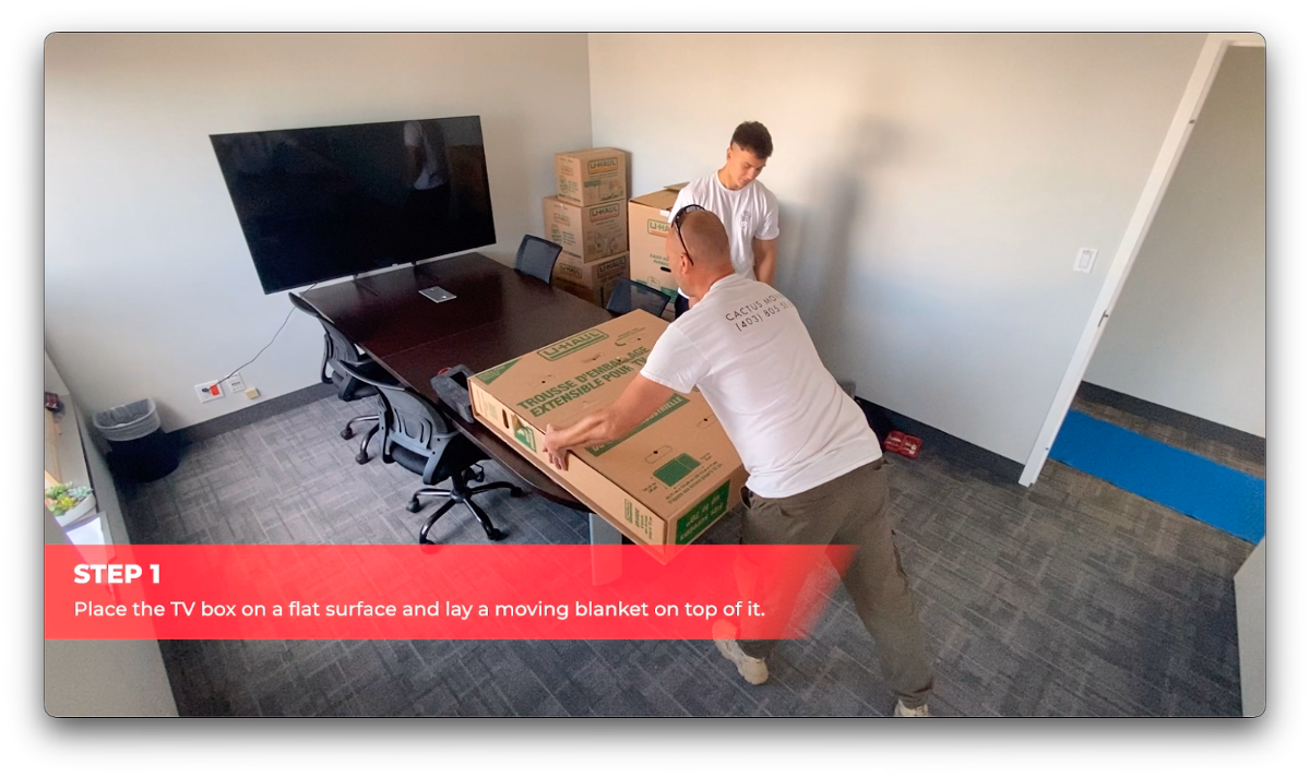 Cactus Moving workers preparing a TV packing box on a table.