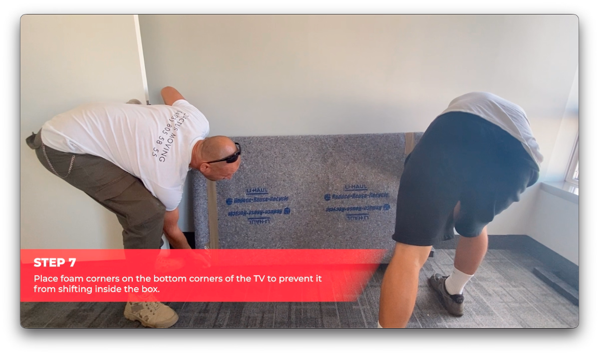 Cactus Moving workers attaching protective foam corners to a wrapped flat-screen TV.